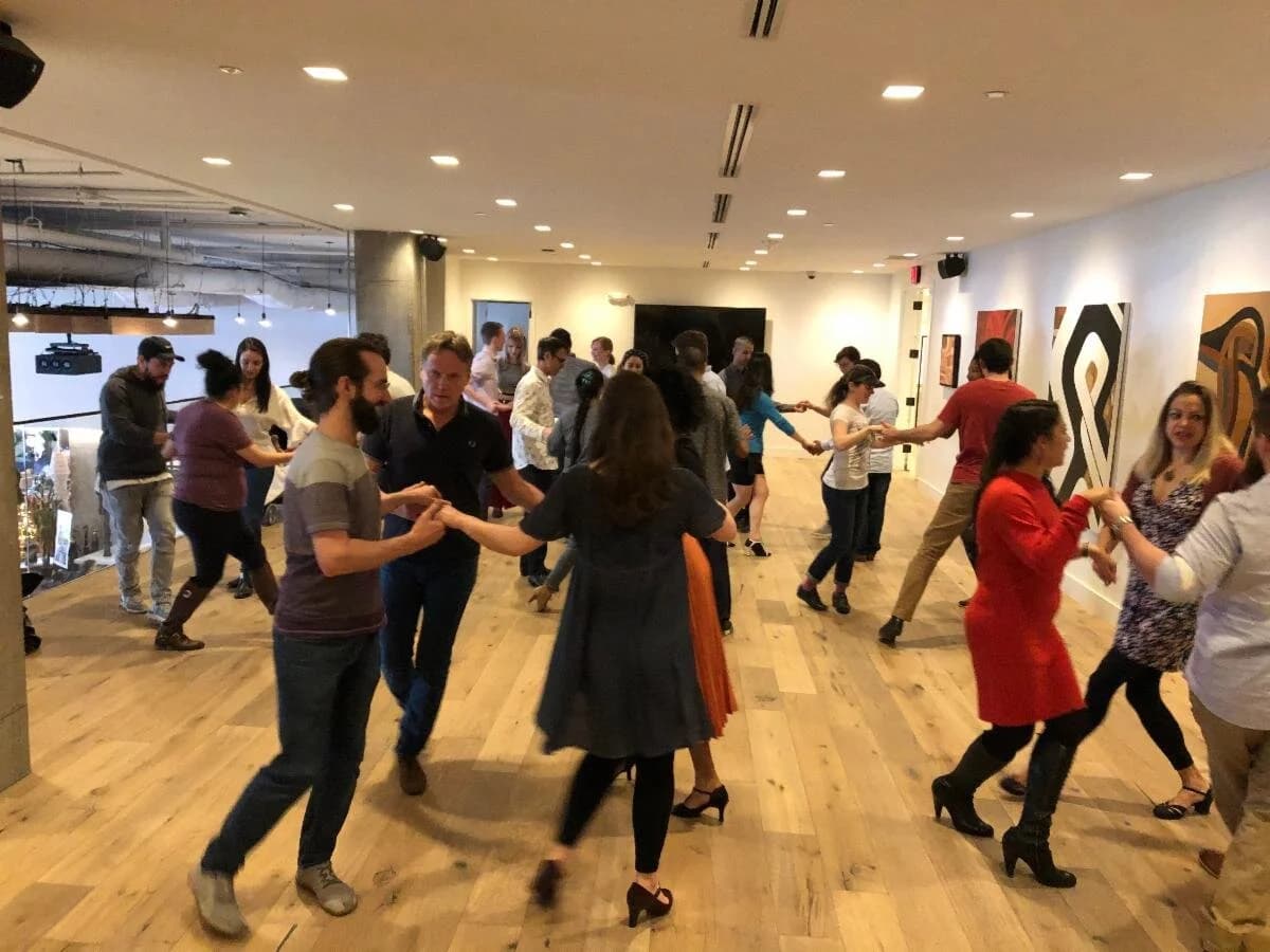 Tango Mercurio dancers gathered under warm evening light